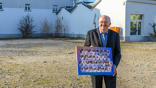 Rektor Ludwig Hilmer präsentiert stolz die Collage der 33 studentischen Mitarbeiter:innen des Testzentrums – ein Geschenk des Studentenrats.