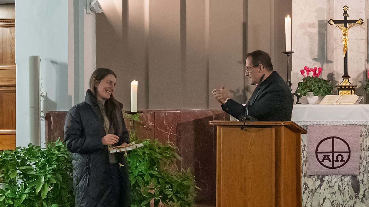 Musiker am Rednerpult mit Dankesgeste gegenüber einer links neben ihm stehenden weiblichen Person