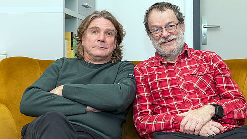 Kein Sofajob: Dirk Labudde und Thomas Villmann (v.l.) sind die ersten HAW-Professoren in Sachsen, die an einer Universität kooptiert sind, um Promotionsverfahren eigenständig durchzuführen. Zwei männliche Personen sitzen auf einen Sofa und schauen gut gelaunt in die Kamera.