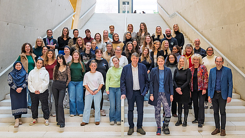 Gruppenfoto mit rund 50 Personen auf großer Treppe.