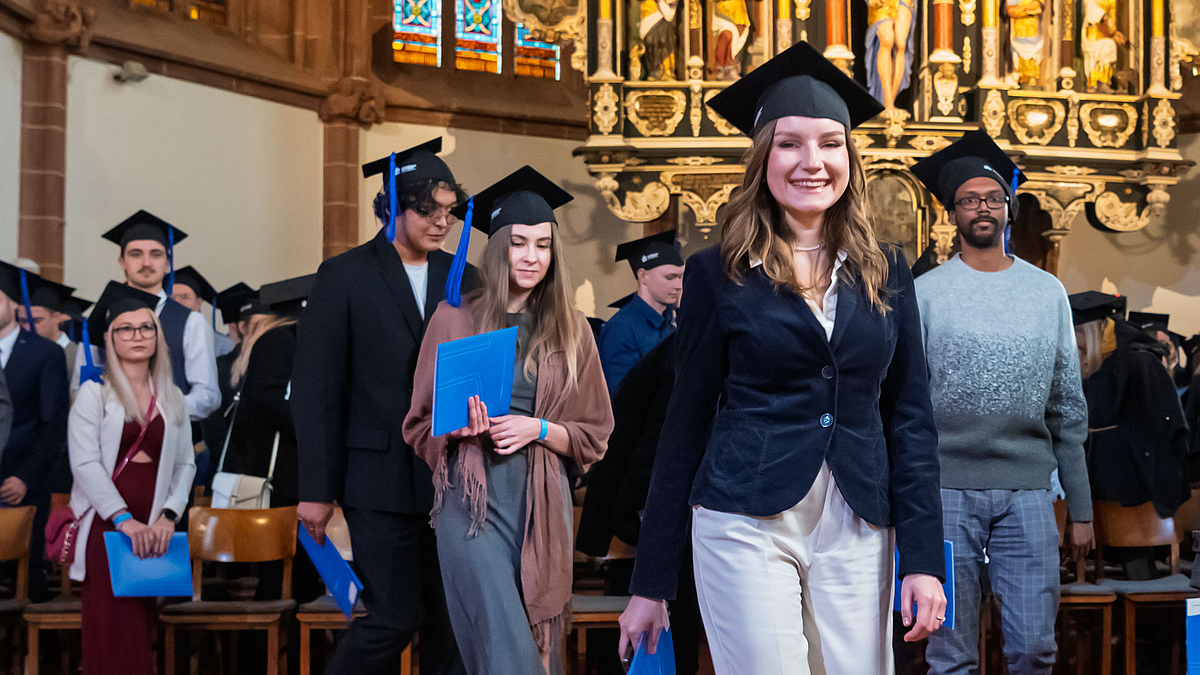 Absolvent:innen ziehen aus dem Altarraum aus.