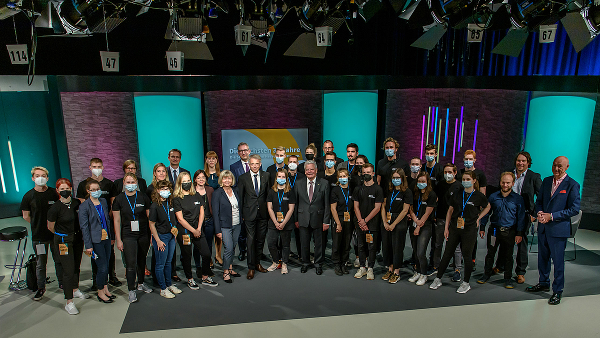 Das Foto zeigt 37 Personen auf der Studiofläche, alle Mitwirkenden vor und hinter den Kulissen, in der Mitte Joachim Gauck, Kanzlerin Sylvia Bäßler und Prorektor Prof. Volker Tolkmitt.