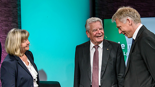 Die Hochschule beeindruckt. Joachim Gauck im Gespräch mit Kanzlerin Sylvia Bäßler und Prorektor Professor Volker Tolkmitt. Das Foto zeigt drei Personen bester Laune. In der Mitte Altbundespräsident Joachim Gauck dem Prorektor Prof. Volker Tolkmitt zugewandt, auf dem Biild rechts. Links ist Hochschulkanzlerin Sylvia Bäßler zu sehen, den Blick beiden Gesprächspartnern zugewandt.