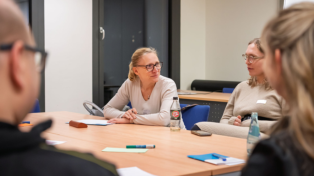 Vier Personen an einem Tisch im Gespräch