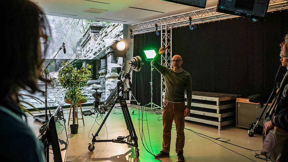 Männliche Person erklärt Studiotechnik.