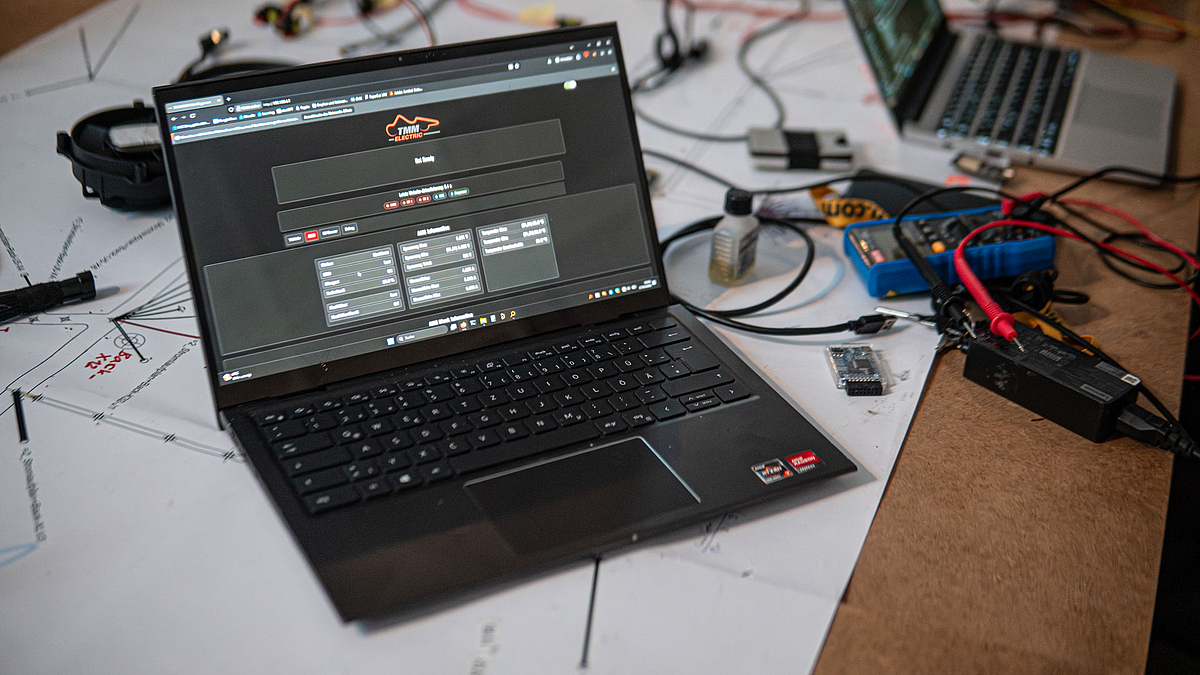 Aufgeklappter Laptop. Auf dem Display ist die Benutzeroberfläche des Diagnosers mit dem Logo von TMM zu sehen.
