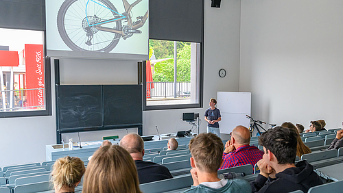 Schule an der Hochschule: Gymnasiast Edwin Rudolph präsentiert im Hörsaal der Hochschule Mittweida die Ergebnisse seiner Facharbeit, in der er die Fahrdynamik unterschiedlicher Fahrrad-Hinterbaugeometrien vergleicht.