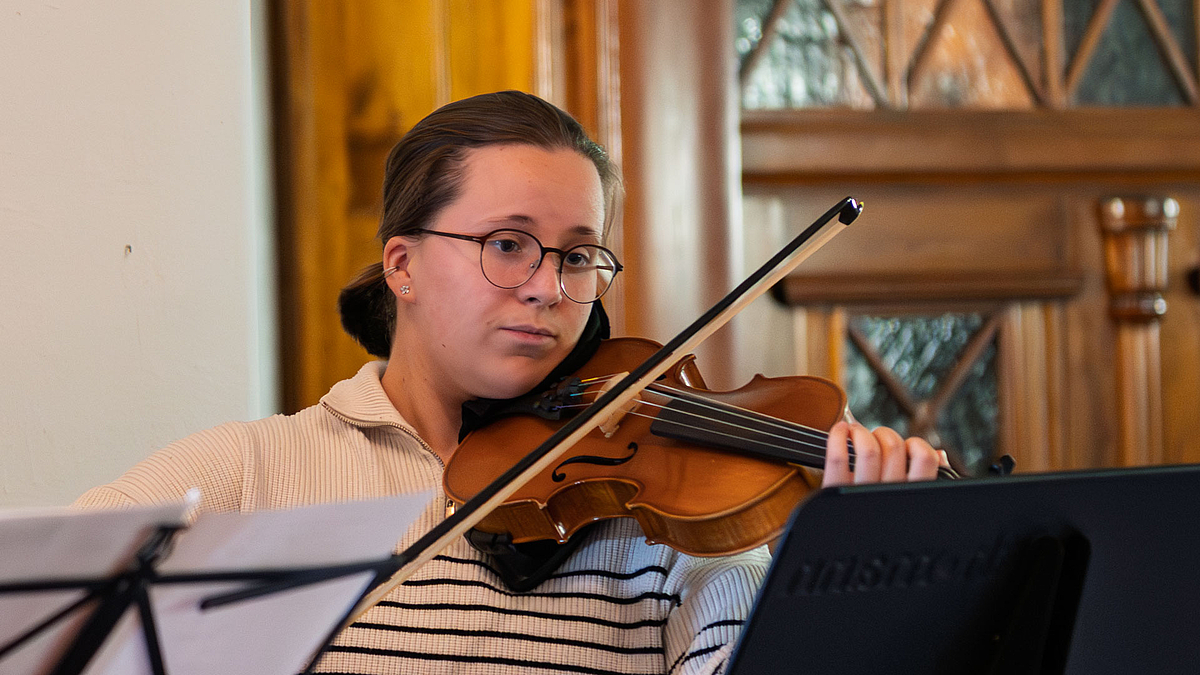 Geigenspielerin hinter Notenständern.