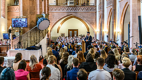Doppelter Abschied: Rektor Ludwig Hilmer bei der letzten Feierlichen Exmatrikulation seiner Amtszeit inmitten der Festgemeinde aus Absolvent:innen, Angehörigen und Professor:innen.