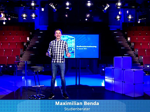 Maximilian Benda moderiert live aus dem TV-Studio der Hochschule. 