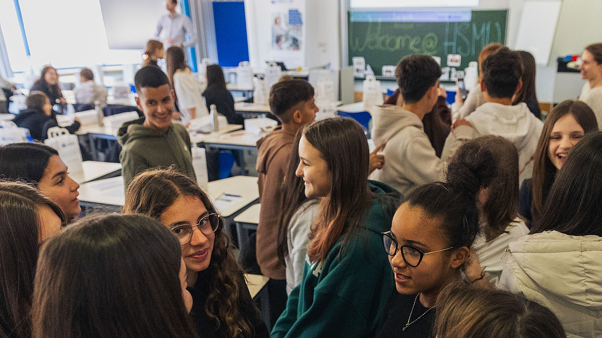 Jugendliche in einem Semiarraum. An die Tafel im Hintergrun ist groß "Welcome @ HSMW" geschrieben.