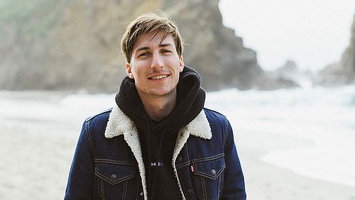 Hat es auf 150 Kinoleinwände bundesweit geschafft: HSMW-Alumnus Pascal Schröder. (Foto: Andreas Schlieter) Porträt in Halbnah vor unscharfer Strandkulisse