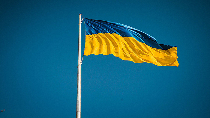 Die blaue-goldene Flagge der Ukraine weht an einem Fahnenmast im Wind